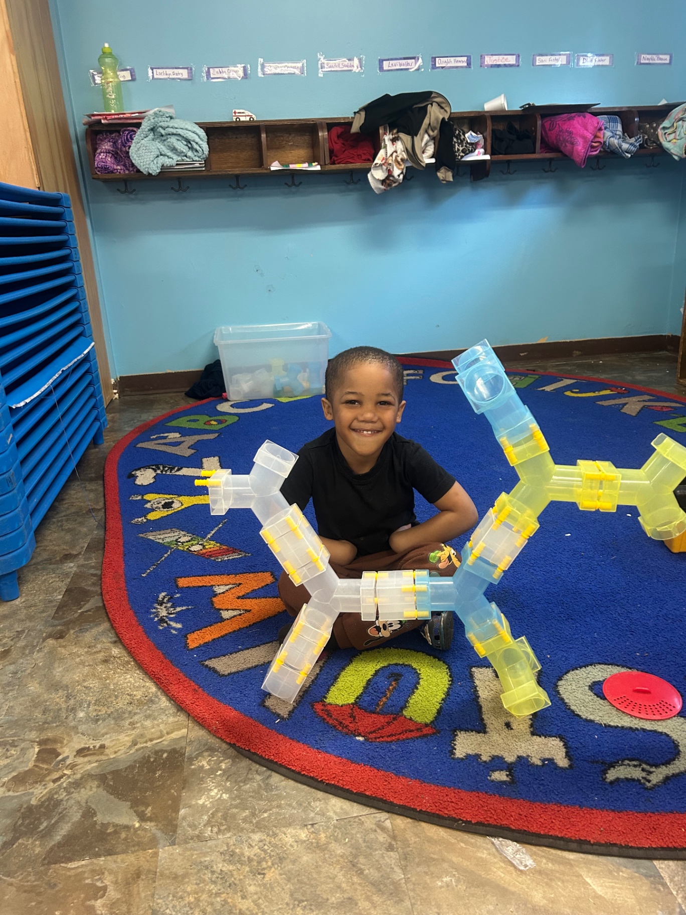 A child smiling with a building blocks creation