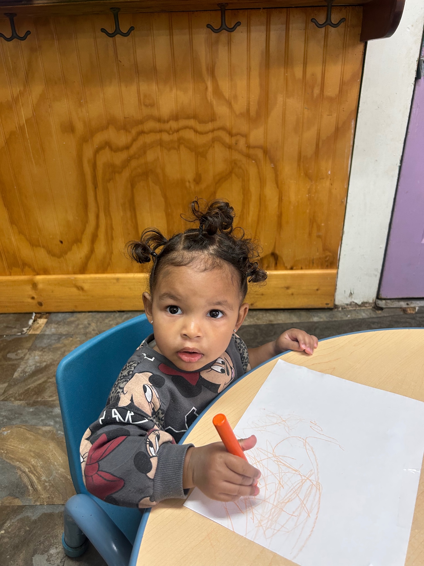 A toddler coloring with a crayon