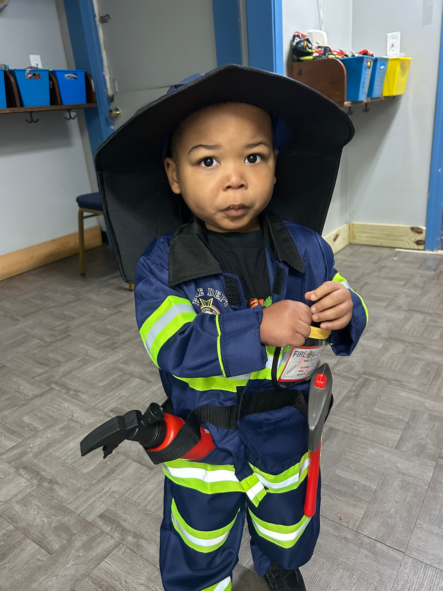 A child dressed as a firefighter during career day
