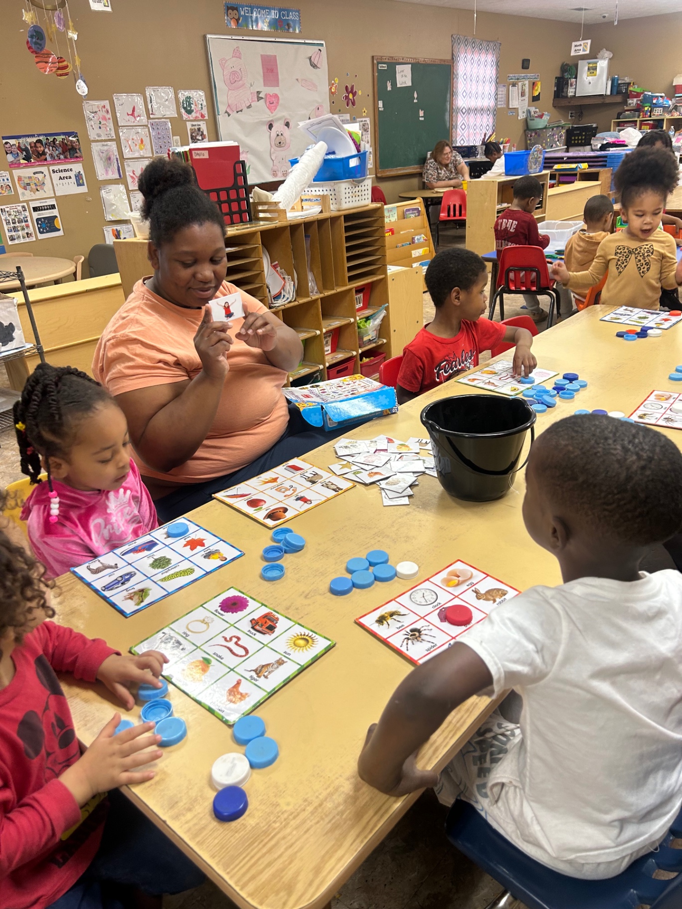 Children laughing while playing with wooden blocks in a sunlit classroom